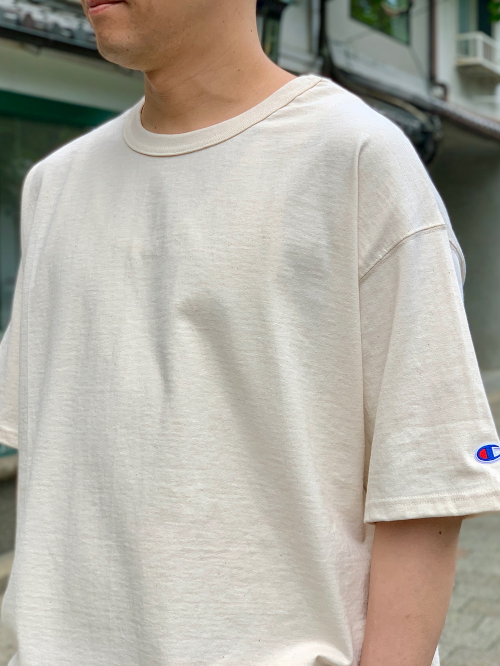 ブラウン系のカーゴパンツ、ベージュ系のTシャツ/カットソー、ブラック系のスニーカーを着用したメンズの夏コーディネートの3枚目の写真