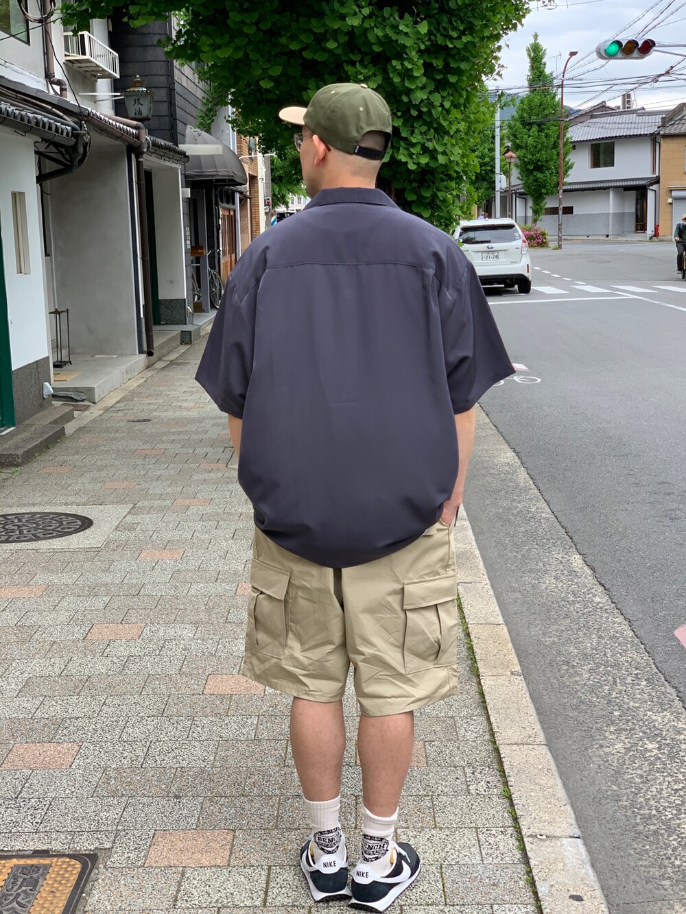 ベージュ系のカーゴパンツ、グレー系のシャツ/ブラウス、ブラック系のスニーカーを着用したメンズの夏コーディネートの2枚目の写真