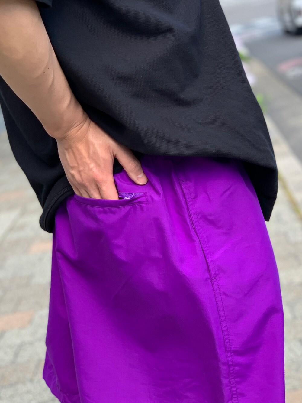 ブラック系のポロシャツ、パープル系のその他パンツ、ブラック系のスニーカーを着用したメンズの夏コーディネートの5枚目の写真