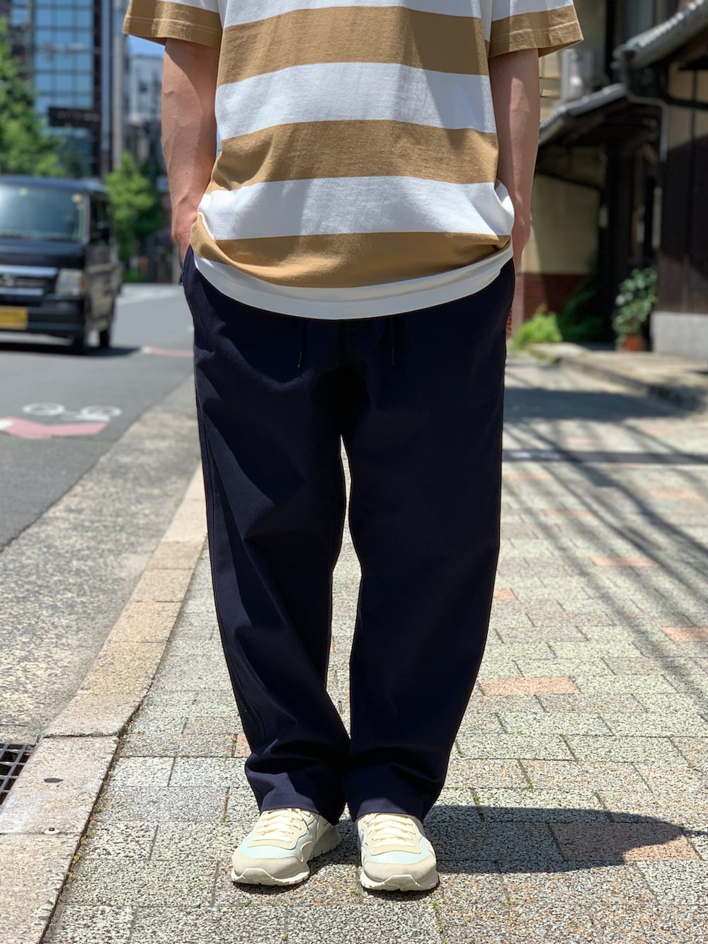 ブラウン系のTシャツ/カットソー、ブルー系のチノパンツ、ベージュ系のスニーカーを着用したメンズの夏コーディネートの5枚目の写真