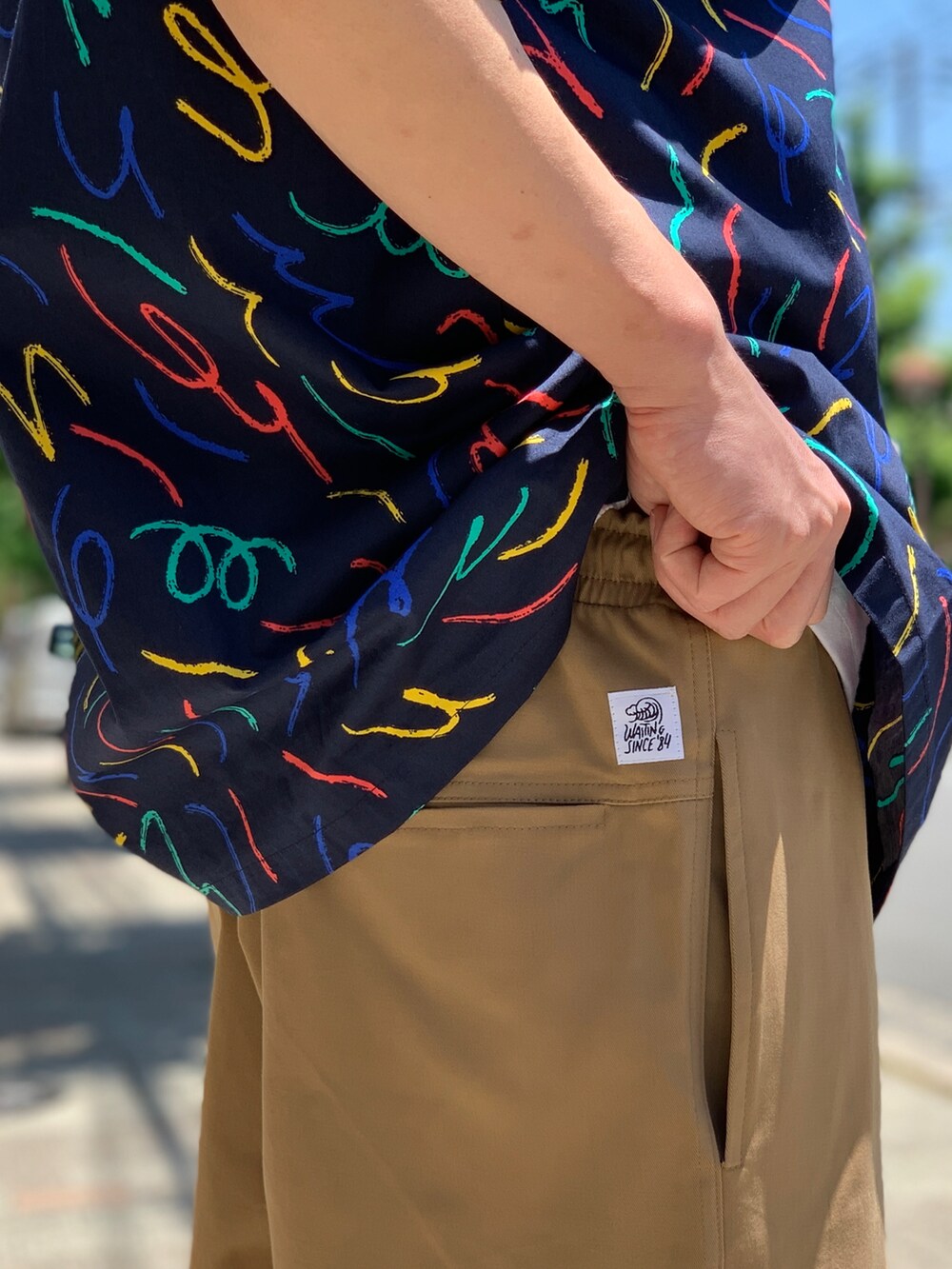 ベージュ系のチノパンツ、ブルー系のシャツ/ブラウス、ブラック系のキャップを着用したメンズの夏コーディネートの5枚目の写真