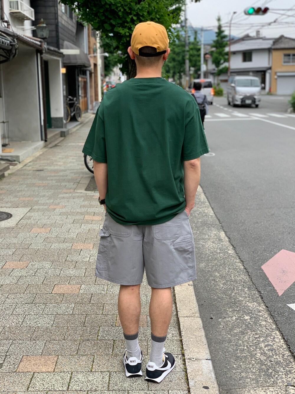 ブラック系のスニーカー、グリーン系のTシャツ/カットソーを着用したメンズの夏コーディネートの2枚目の写真