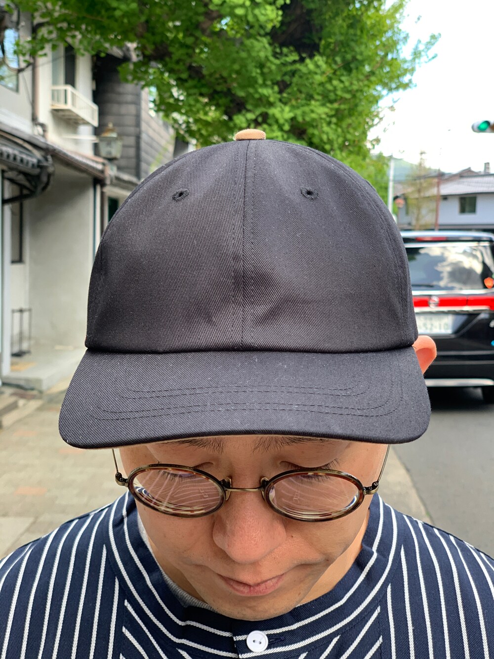 ブラック系のシャツ/ブラウス、ブラウン系のチノパンツ、ブラック系のスニーカーを着用したメンズの夏コーディネートの2枚目の写真