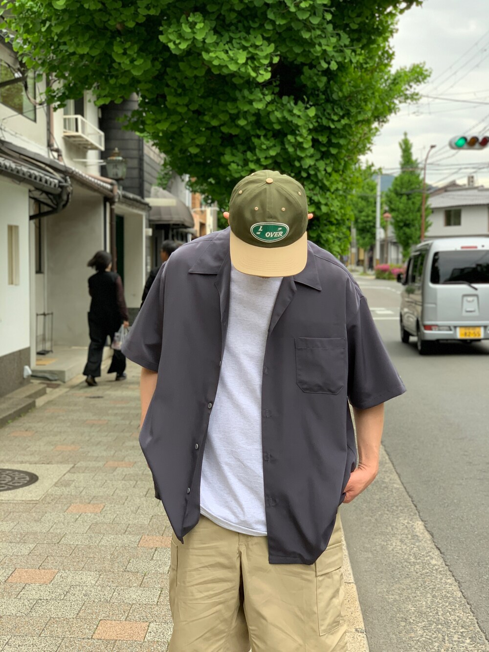 ベージュ系のカーゴパンツ、グレー系のシャツ/ブラウス、ブラック系のスニーカーを着用したメンズの夏コーディネートの3枚目の写真