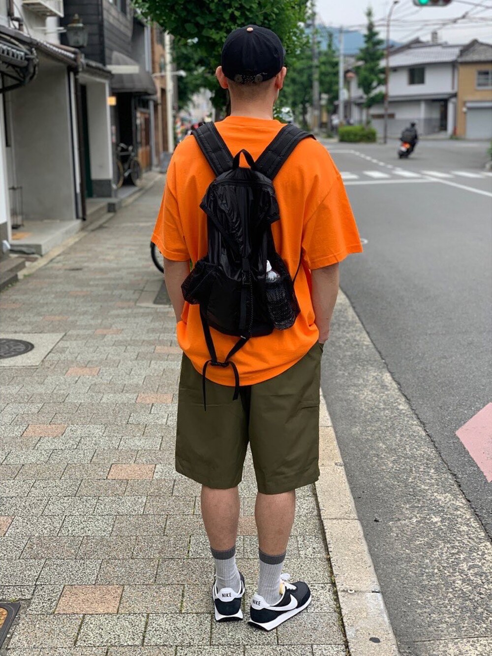 オレンジ系のTシャツ/カットソーを着用したメンズの夏コーディネートの2枚目の写真