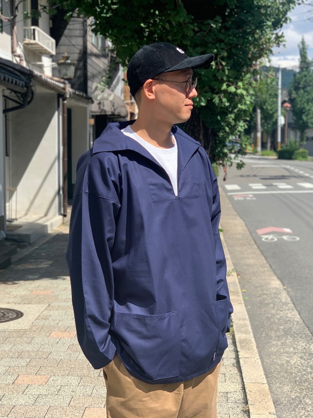 ベージュ系のチノパンツ、ブルー系のジャケット/アウター、ブラック系のスニーカーを着用したメンズの秋コーディネートの3枚目の写真