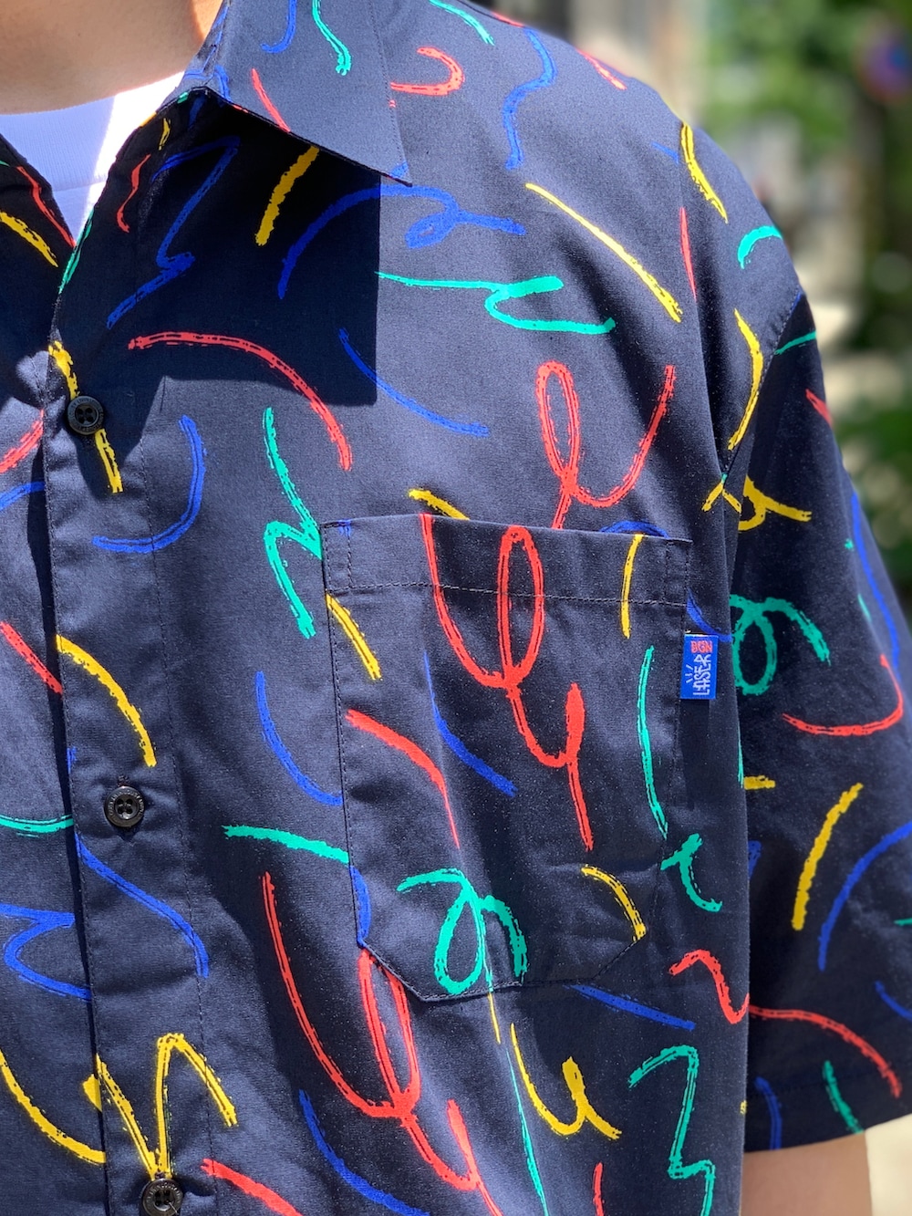 ベージュ系のチノパンツ、ブルー系のシャツ/ブラウス、ブラック系のキャップを着用したメンズの夏コーディネートの4枚目の写真