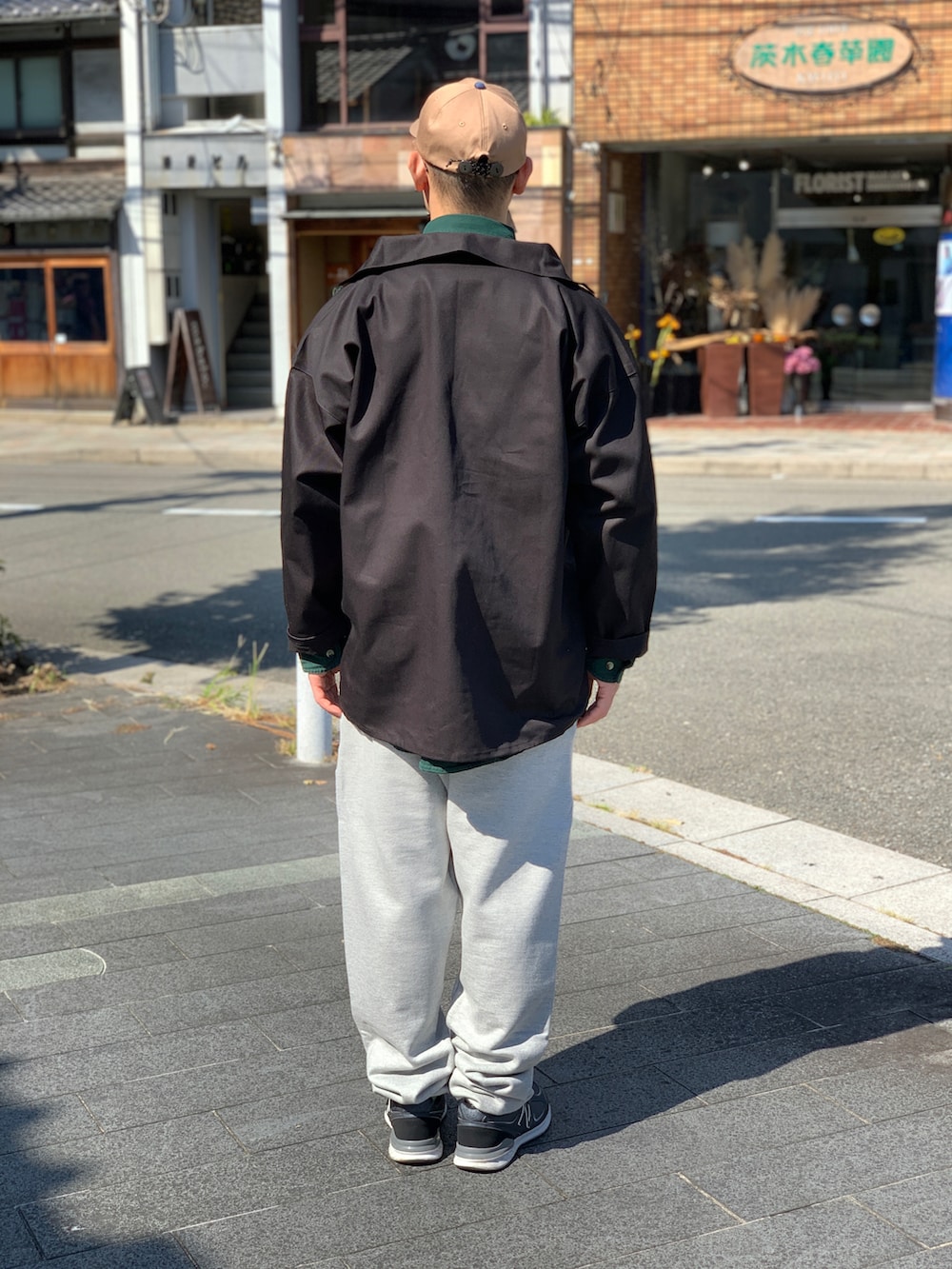 グレー系のスウェットパンツ、ブラック系のカバーオール、グリーン系のシャツ/ブラウスを着用したメンズの秋コーディネートの2枚目の写真