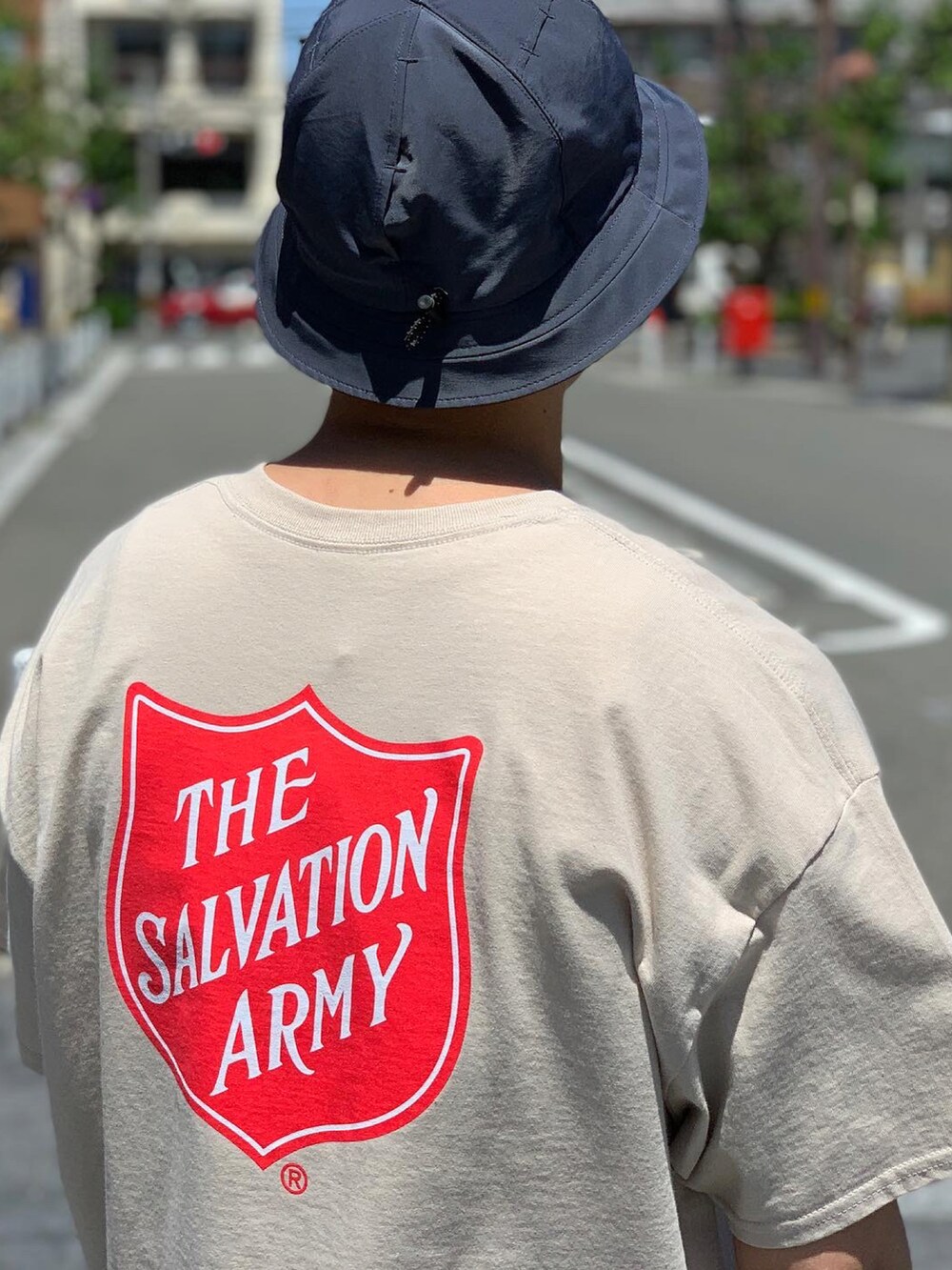 グリーン系のカーゴパンツ、ブラック系のスニーカー、ブラック系のハットを着用したメンズの夏コーディネートの4枚目の写真