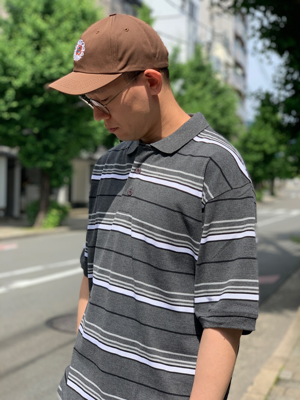 グレー系のポロシャツ、グリーン系のチノパンツ、ブラック系のスニーカーを着用したメンズの秋コーディネートの4枚目の写真