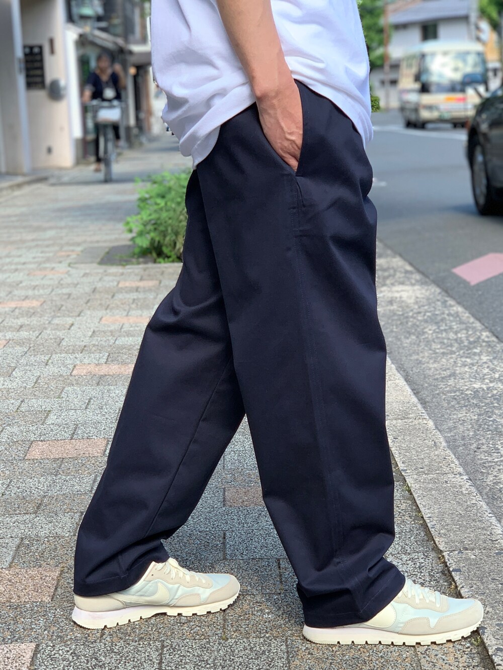 ホワイト系のポロシャツ、ブルー系のチノパンツを着用したメンズの夏コーディネートの5枚目の写真