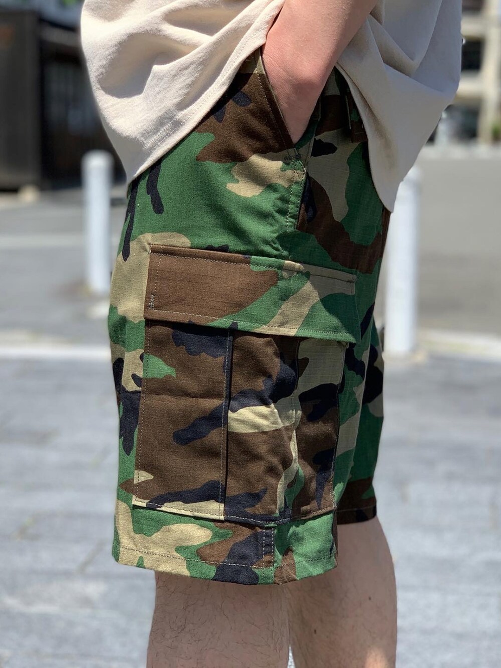 グリーン系のカーゴパンツ、ブラック系のスニーカー、ブラック系のハットを着用したメンズの夏コーディネートの5枚目の写真