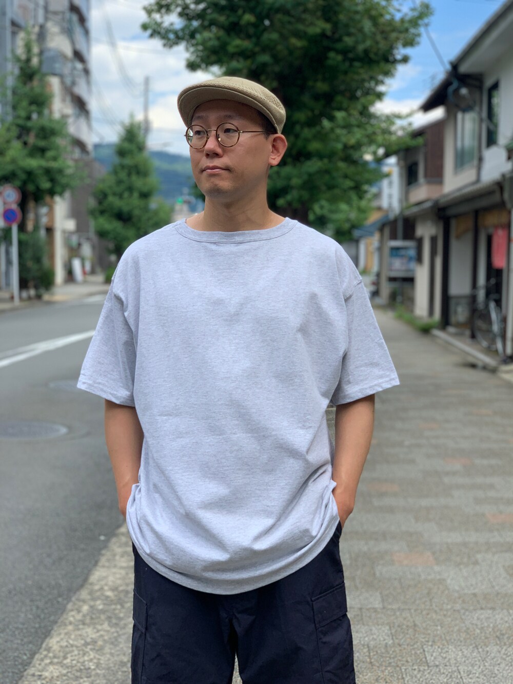 ベージュ系のTシャツ/カットソー、ブルー系のカーゴパンツを着用したメンズの夏コーディネートの3枚目の写真