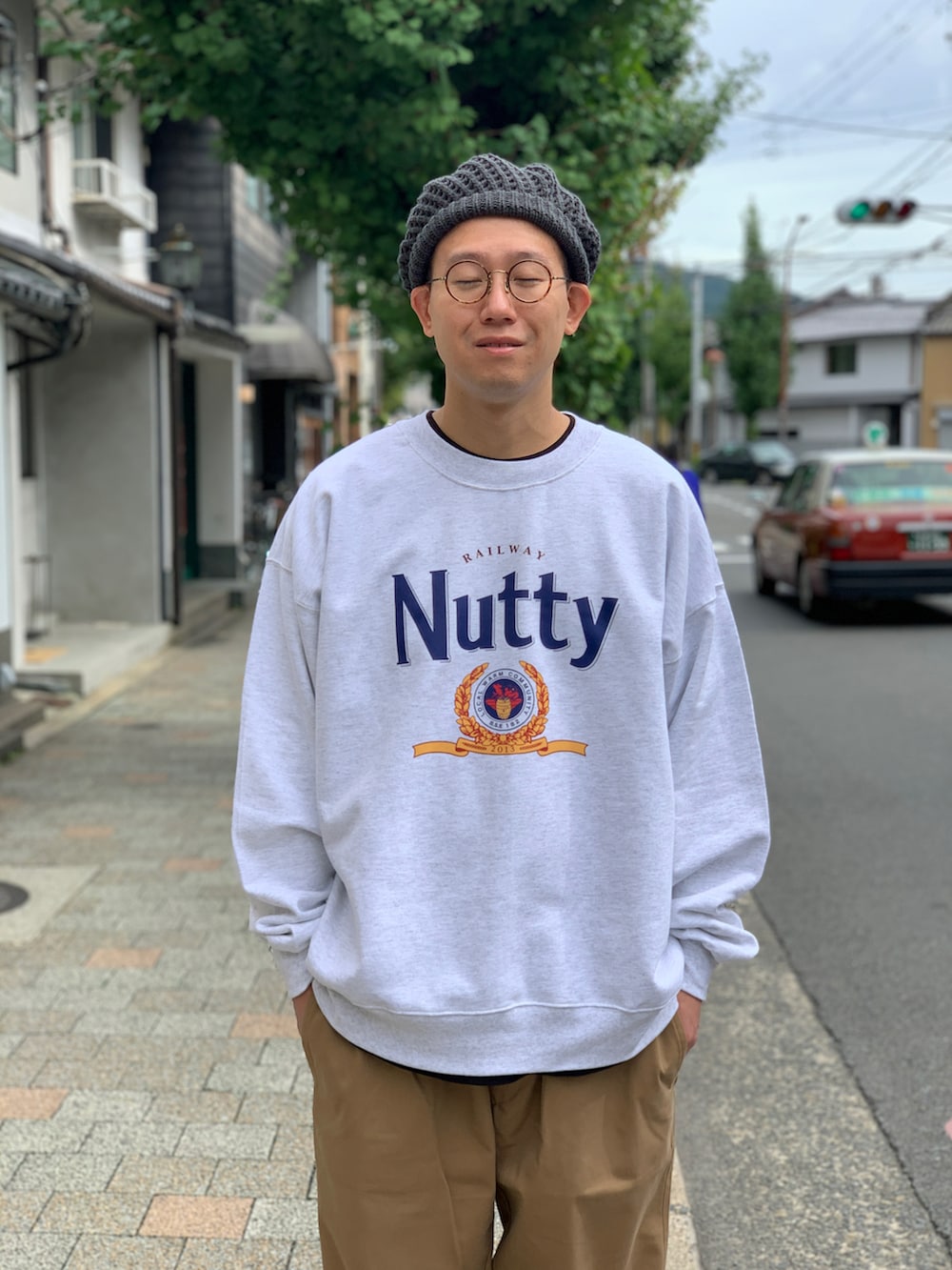 ベージュ系のチノパンツ、グレー系のスウェット、グレー系のニットキャップ/ビーニーを着用したメンズの秋コーディネートの3枚目の写真