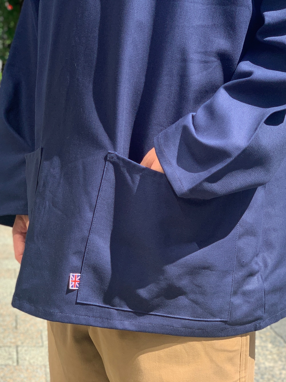 ベージュ系のチノパンツ、ブルー系のジャケット/アウター、ブラック系のスニーカーを着用したメンズの秋コーディネートの4枚目の写真