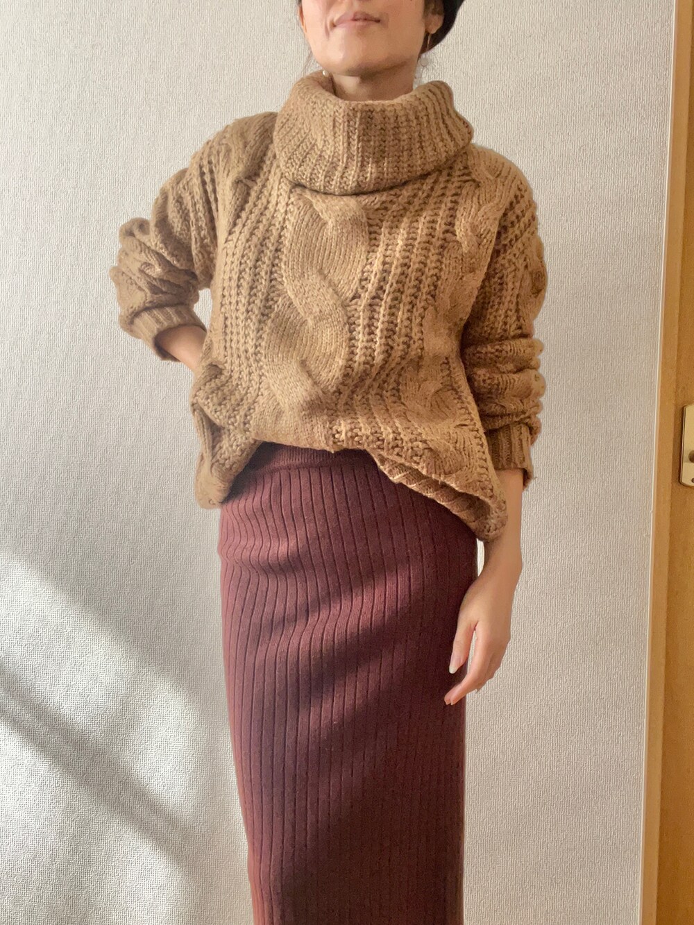 ブラウン系のスカート、ブラウン系のニット/セーター、ブラック系のハンチング/ベレー帽を着用したレディースの秋コーディネートの2枚目の写真