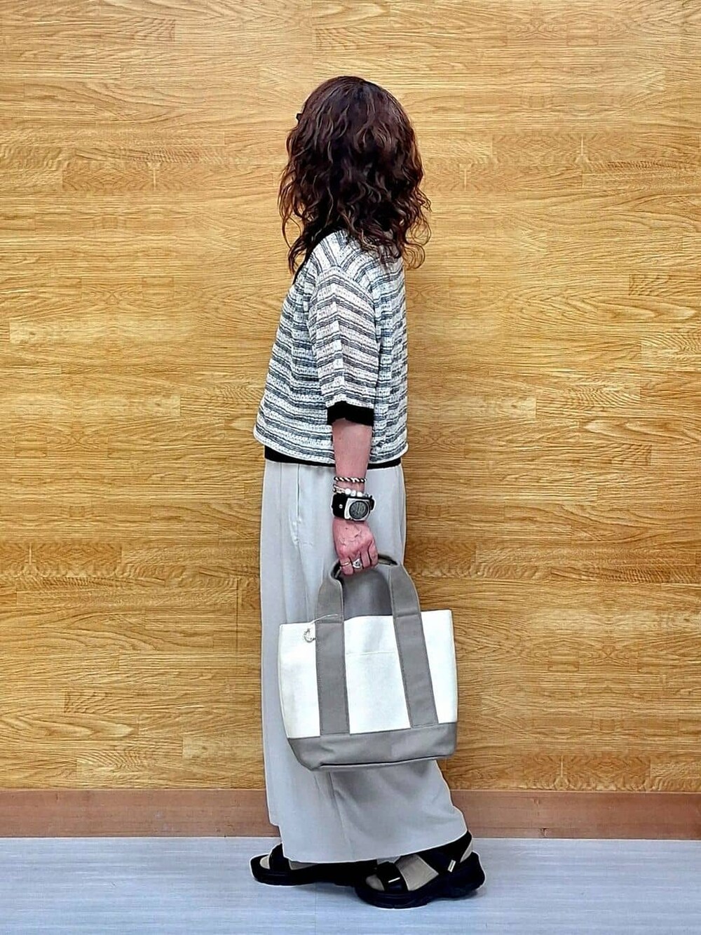 ベージュ系のその他パンツ、ブラック系のサンダル、ベージュ系のトートバッグを着用したレディースの春コーディネートの2枚目の写真