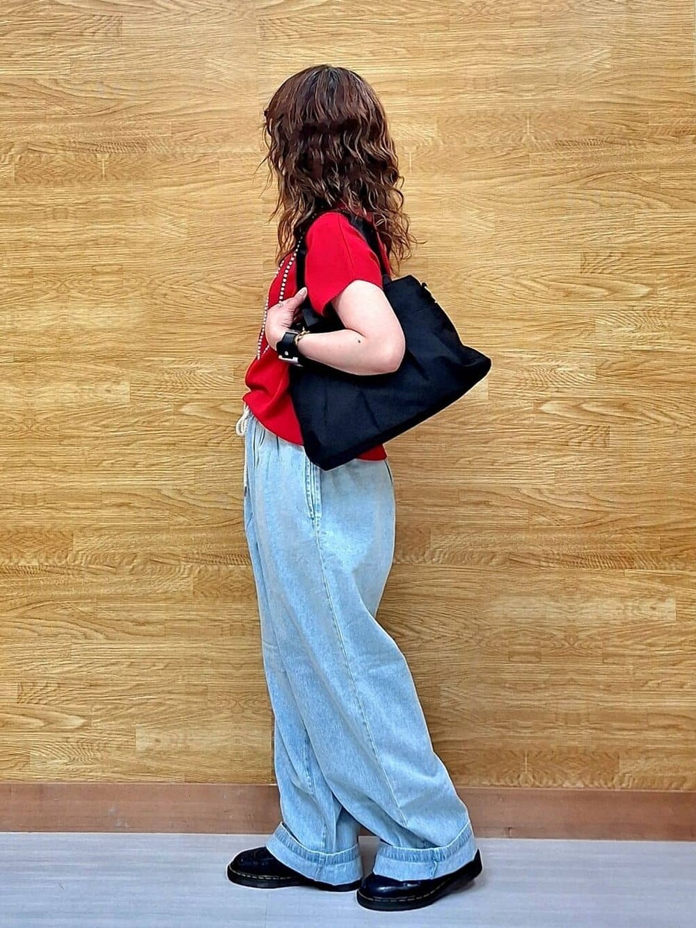 レッド系のニット/セーター、ブルー系のその他パンツ、ブラック系のトートバッグを着用したレディースの夏コーディネートの2枚目の写真
