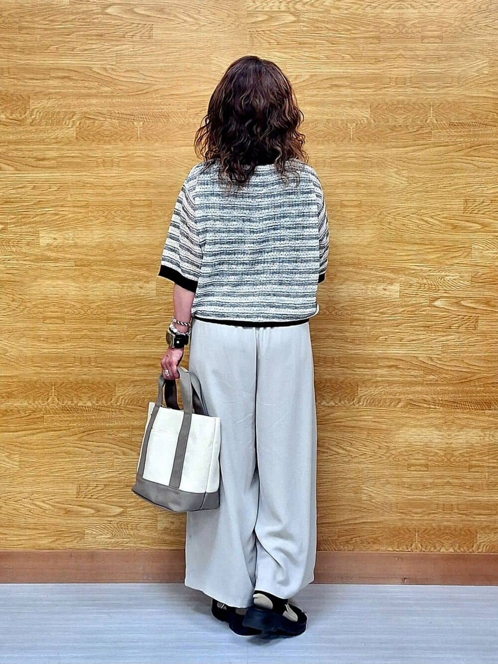 ベージュ系のその他パンツ、ブラック系のサンダル、ベージュ系のトートバッグを着用したレディースの春コーディネートの3枚目の写真