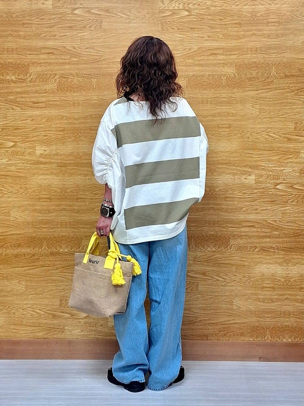 グリーン系のTシャツ/カットソー、ブルー系のデニムパンツ、ブラック系のサンダルを着用したレディースの春コーディネートの3枚目の写真