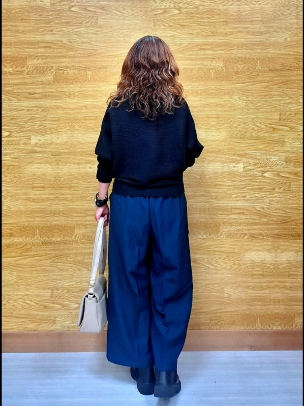 ブラック系のニット/セーター、グリーン系のその他パンツ、ベージュ系のショルダーバッグを着用したレディースの秋コーディネートの4枚目の写真