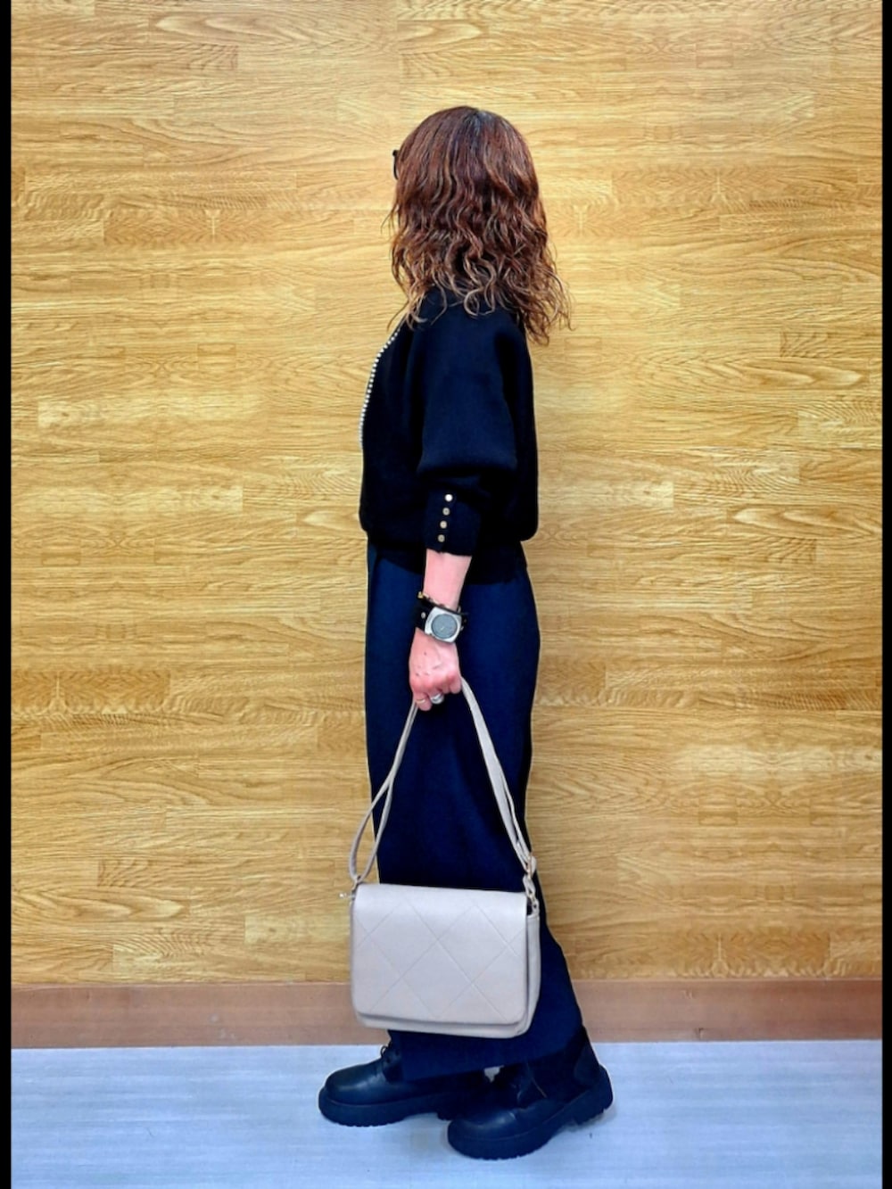 ブラック系のニット/セーター、グリーン系のその他パンツ、ベージュ系のショルダーバッグを着用したレディースの秋コーディネートの3枚目の写真