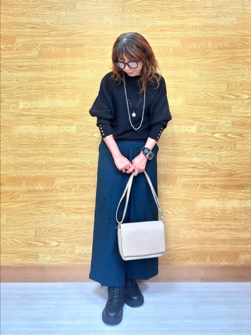 ブラック系のニット/セーター、グリーン系のその他パンツ、ベージュ系のショルダーバッグを着用したレディースの秋コーディネートの2枚目の写真