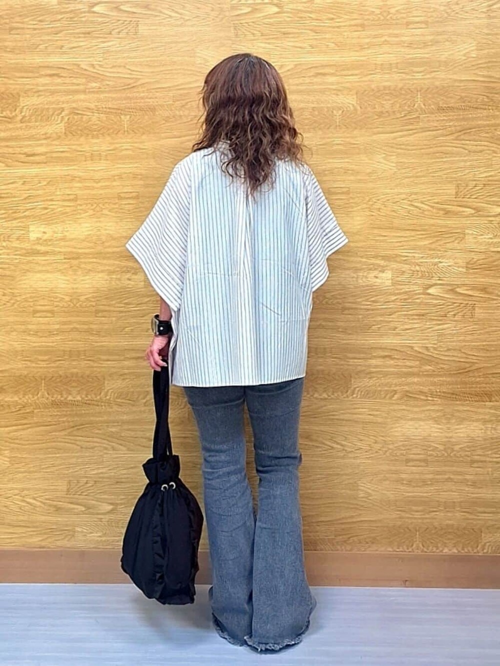ベージュ系のシャツ/ブラウス、ブラック系のデニムパンツ、ブラック系のトートバッグを着用したレディースの夏コーディネートの3枚目の写真