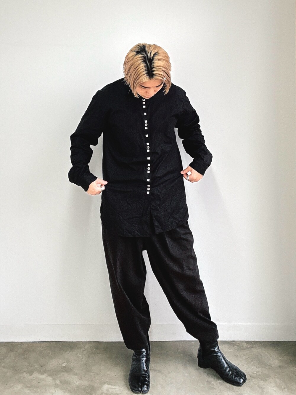 ブラック系のシャツ/ブラウス、ブラック系のスラックス、ブラック系のブーツを着用したメンズの秋コーディネートの2枚目の写真