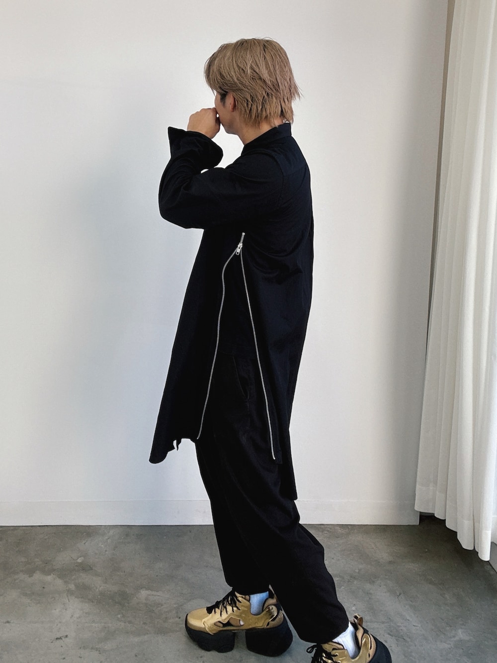 ゴールド系のスニーカー、ブラック系のスラックス、ブラック系のシャツ/ブラウスを着用したメンズの秋コーディネートの2枚目の写真