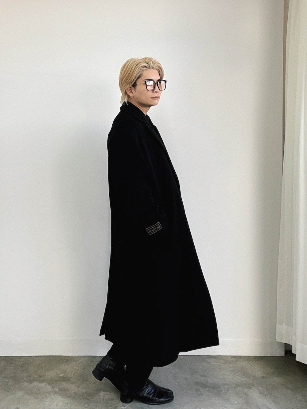 ブラック系のブーツ、ブラック系のチェスターコート、ブラック系のシャツ/ブラウスを着用したメンズの冬コーディネートの2枚目の写真