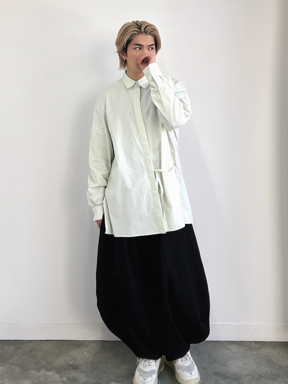 ホワイト系のスニーカー、ブラック系のスラックス、グリーン系のシャツ/ブラウスを着用したメンズの冬コーディネートの2枚目の写真