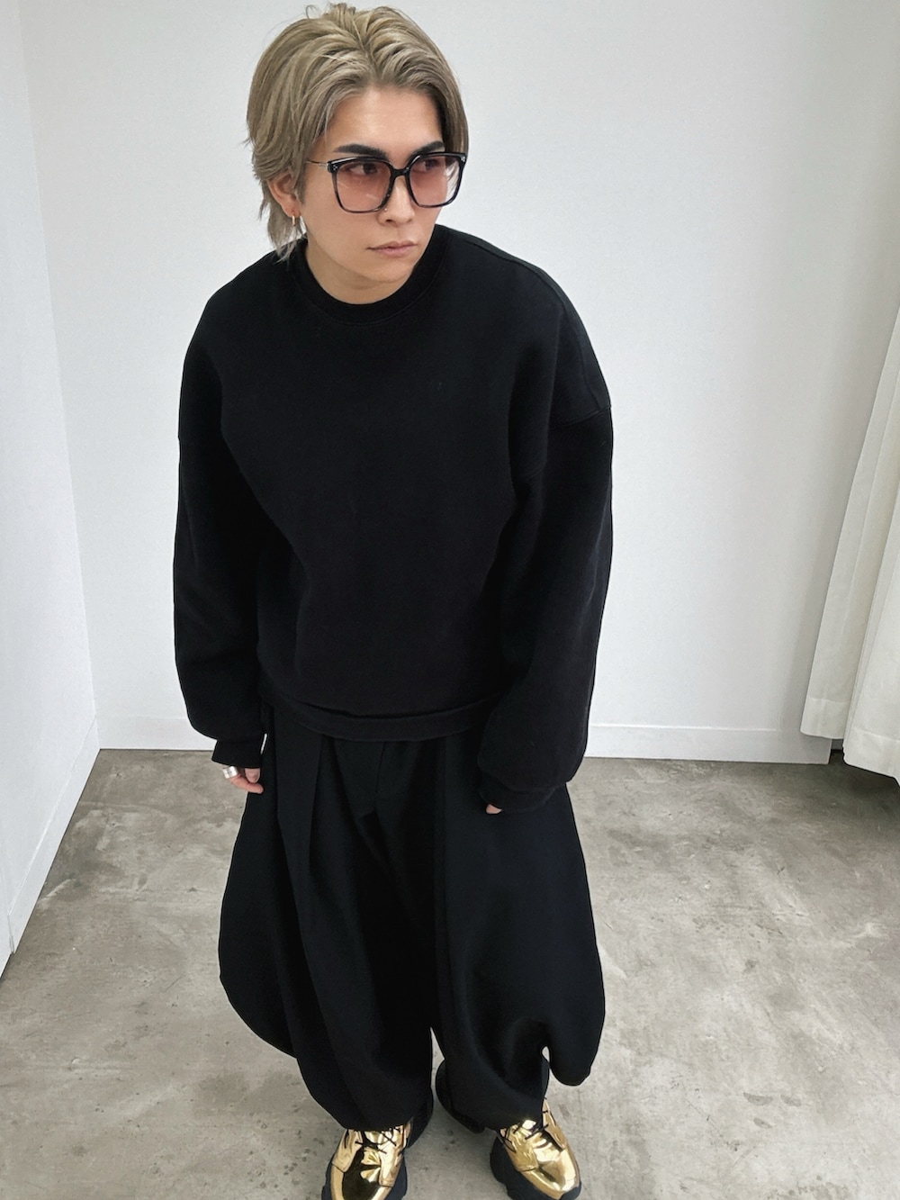 ゴールド系のスニーカー、ゴールド系のスニーカー、ブラック系のスラックスを着用したメンズの冬コーディネートの2枚目の写真