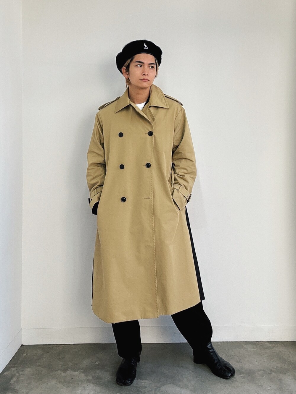 ベージュ系のトレンチコート、ブラック系のブーツ、ブラック系のハンチング/ベレー帽を着用したメンズの秋コーディネートの2枚目の写真