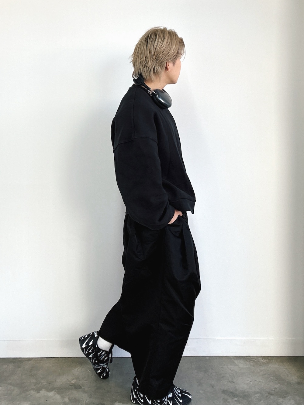 ブラック系のスニーカー、ホワイト系のスニーカー、ブラック系のスラックスを着用したメンズの冬コーディネートの3枚目の写真