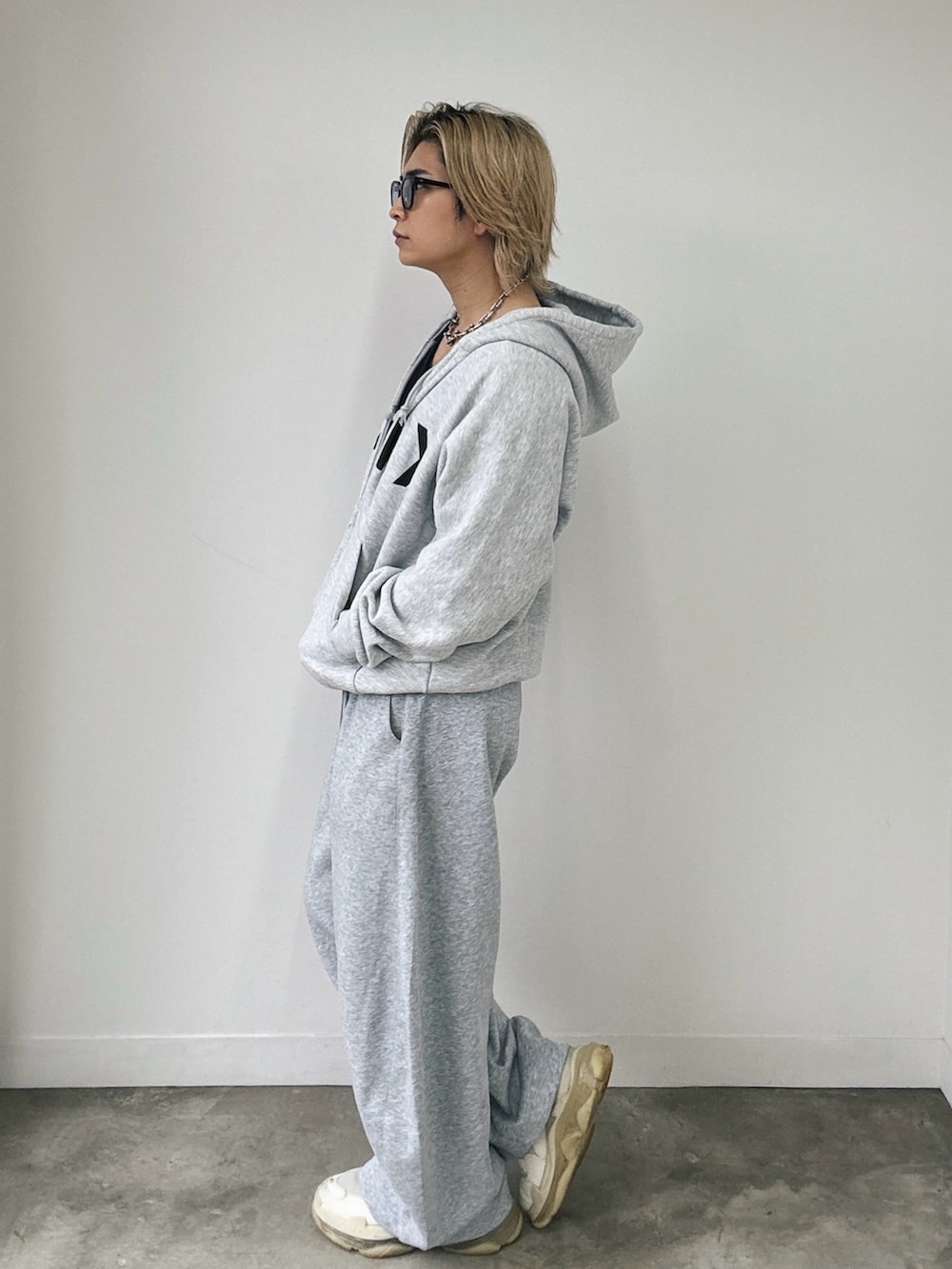 グレー系のパーカー、グレー系のスウェットパンツ、ベージュ系のスニーカーを着用したメンズの春コーディネートの2枚目の写真