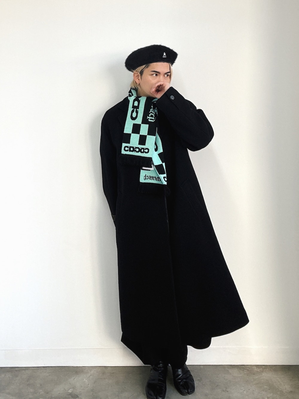 ブラック系のブーツ、ブラック系のチェスターコート、ブラック系のチノパンツを着用したメンズの冬コーディネートの3枚目の写真