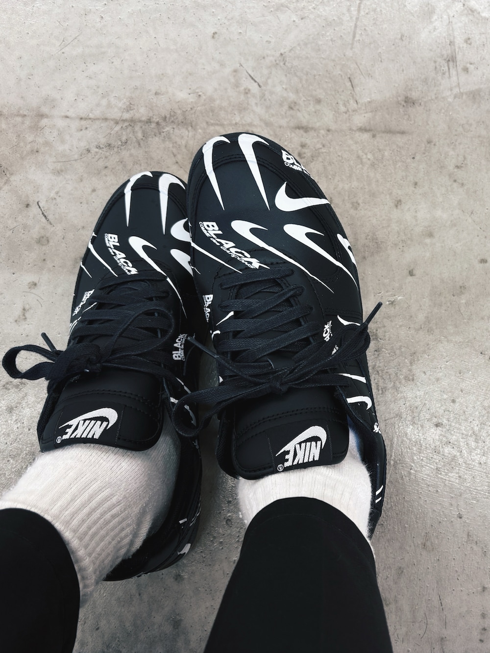 ブラック系のダウンジャケット/コート、ブラック系のスラックス、ブラック系のスニーカーを着用したメンズの冬コーディネートの2枚目の写真