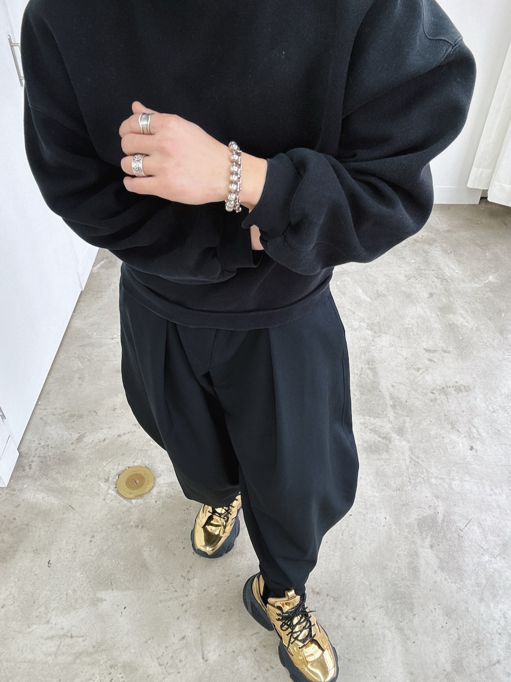 ゴールド系のスニーカー、ゴールド系のスニーカー、ブラック系のスラックスを着用したメンズの冬コーディネートの3枚目の写真