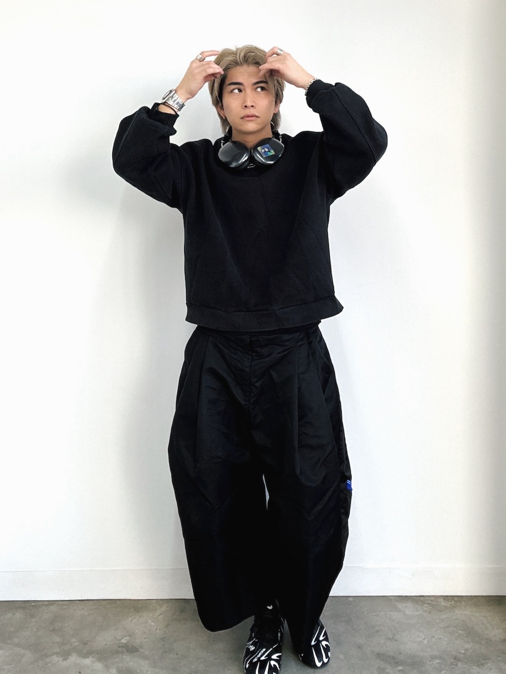 ブラック系のスニーカー、ホワイト系のスニーカー、ブラック系のスラックスを着用したメンズの冬コーディネートの2枚目の写真