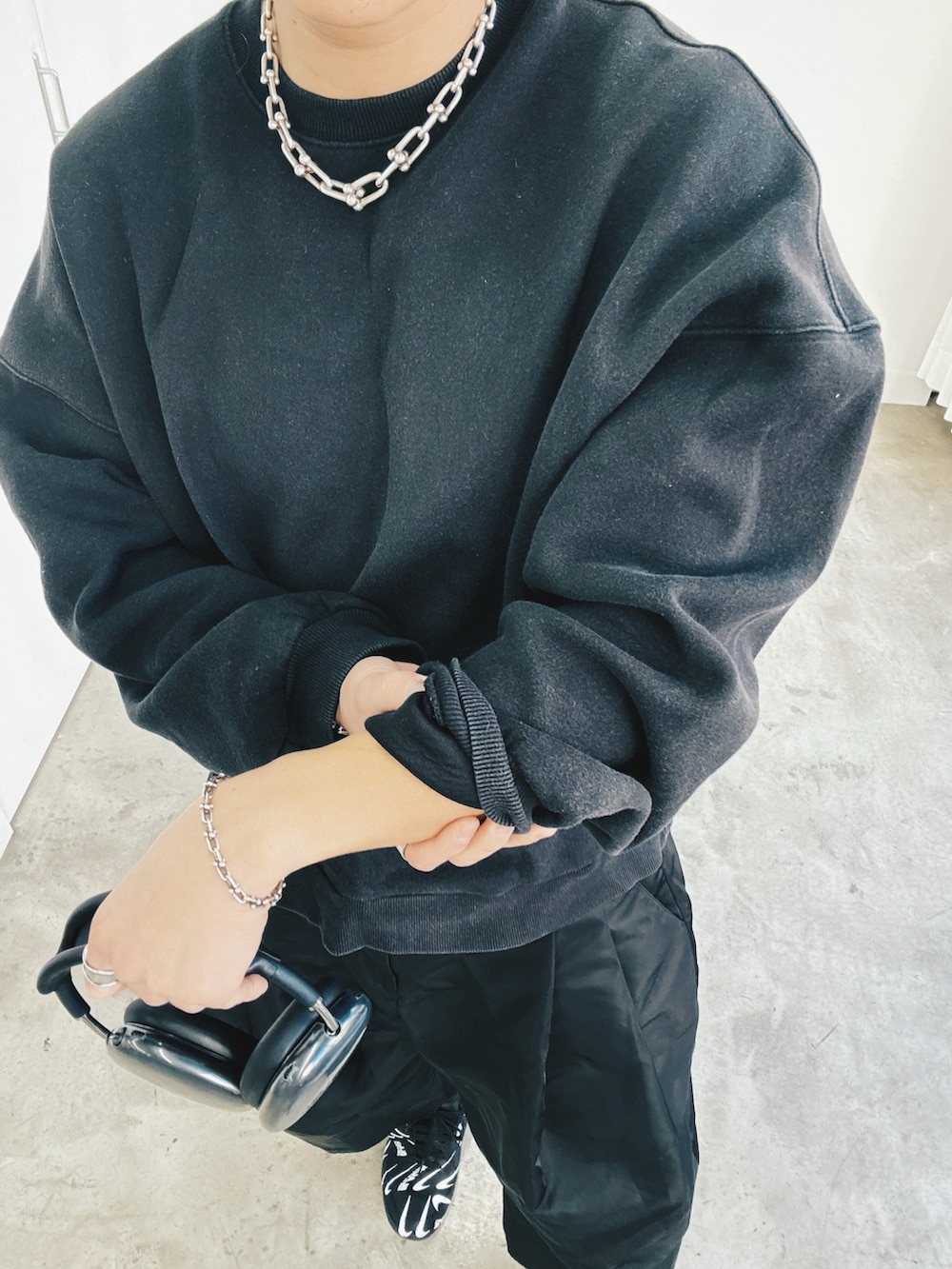 ブラック系のスニーカー、ホワイト系のスニーカー、ブラック系のスラックスを着用したメンズの冬コーディネートの5枚目の写真