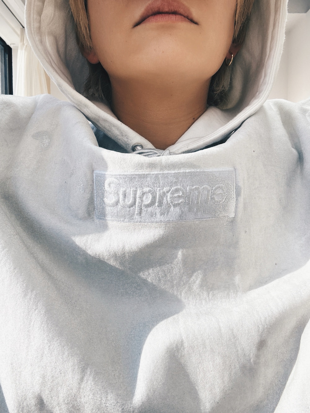 ホワイト系のパーカー、ホワイト系のパーカー、ブラック系のスラックスを着用したメンズの冬コーディネートの3枚目の写真