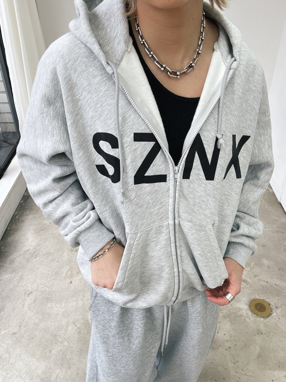 グレー系のパーカー、グレー系のスウェットパンツ、ベージュ系のスニーカーを着用したメンズの春コーディネートの3枚目の写真