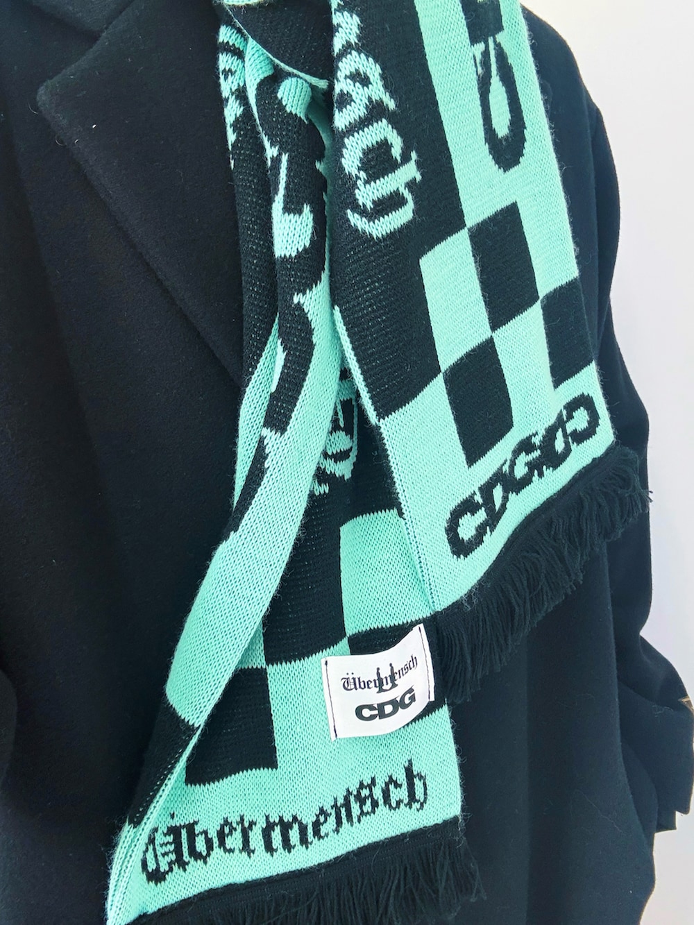 ブラック系のブーツ、ブラック系のチェスターコート、ブラック系のチノパンツを着用したメンズの冬コーディネートの4枚目の写真