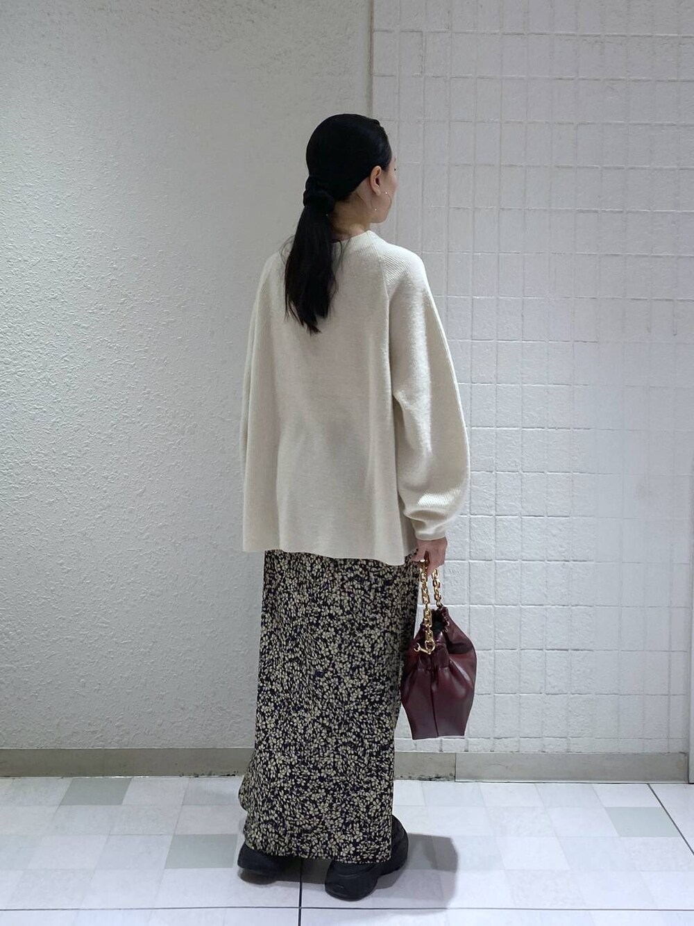 ホワイト系のニット/セーター、レッド系のショルダーバッグ、ブラック系のスカートを着用したレディースの冬コーディネートの4枚目の写真