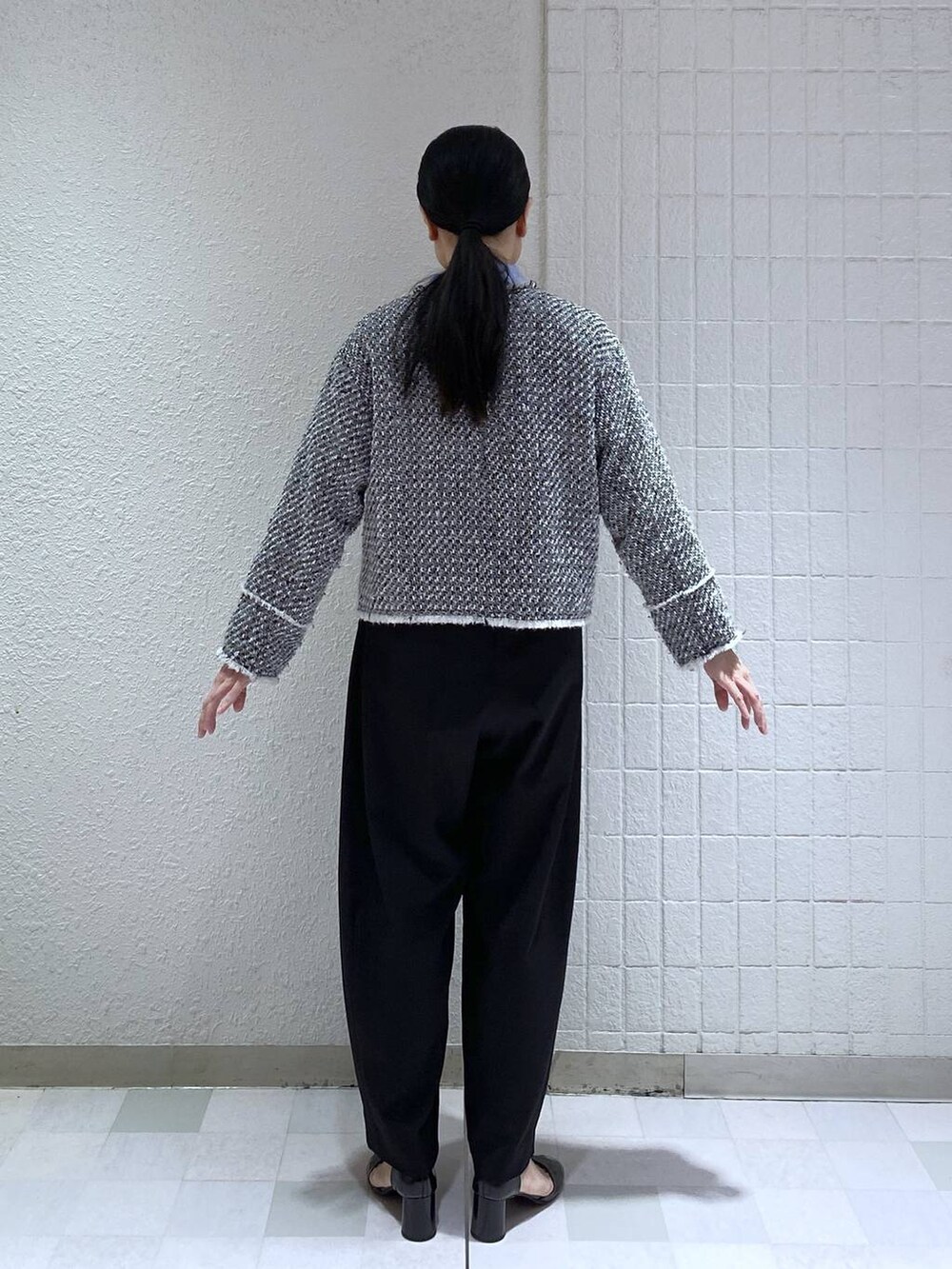 ブラック系のスラックス、ブルー系のシャツ/ブラウス、ブラック系のノーカラージャケットを着用したレディースの冬コーディネートの4枚目の写真