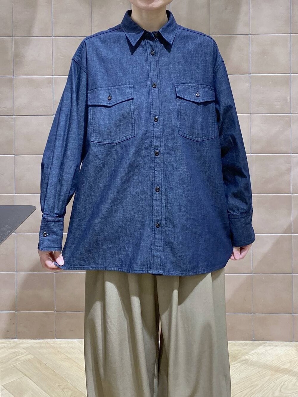 ベージュ系のスラックス、ブルー系のシャツ/ブラウスを着用したレディースの冬コーディネートの3枚目の写真