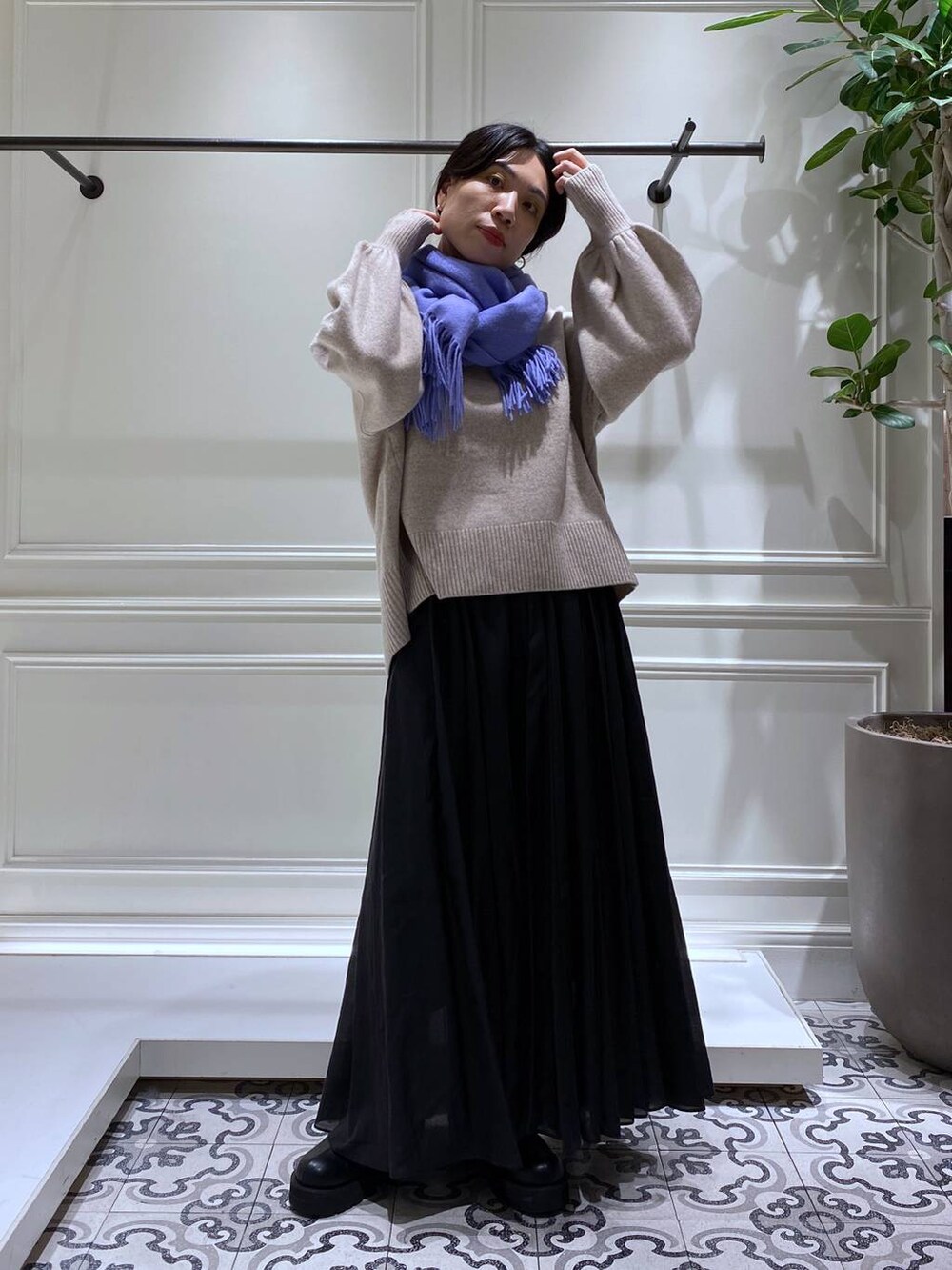 ベージュ系のニット/セーター、ブラック系のスカート、ブラック系のブーツを着用したレディースの冬コーディネートの2枚目の写真