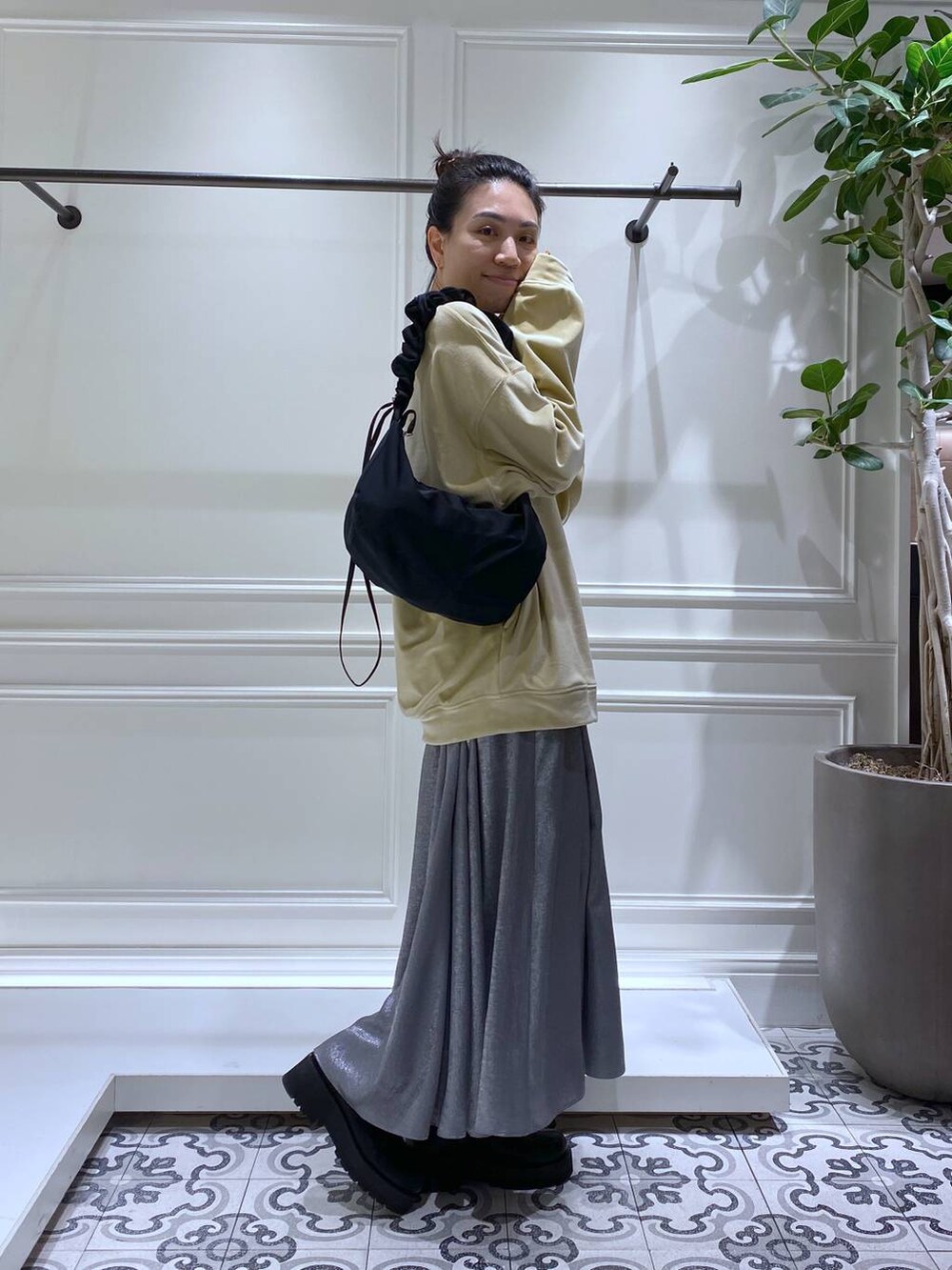 ブラック系のブーツ、ブラック系のショルダーバッグ、グレー系のスカートを着用したレディースの冬コーディネートの3枚目の写真