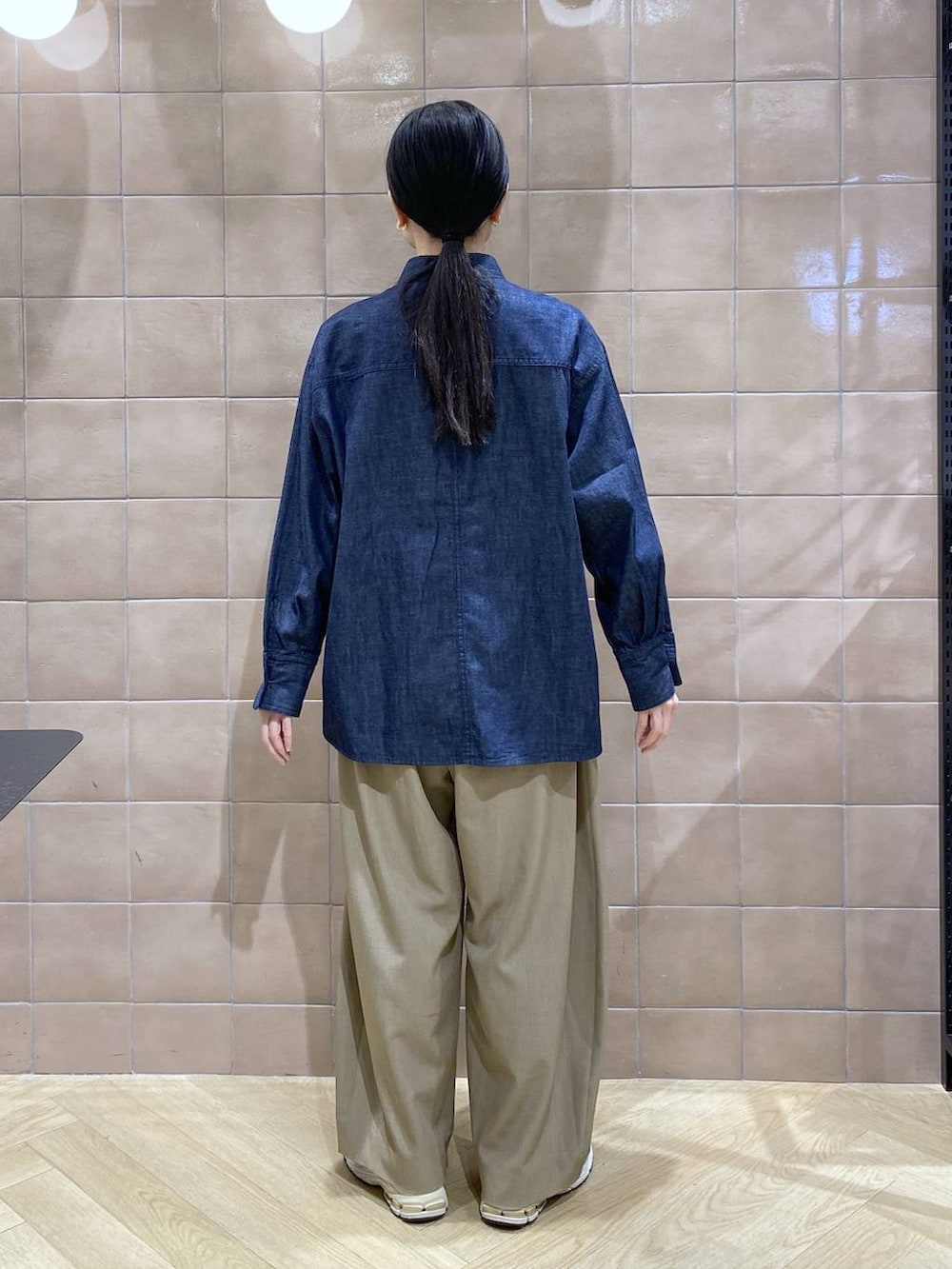 ベージュ系のスラックス、ブルー系のシャツ/ブラウスを着用したレディースの冬コーディネートの5枚目の写真